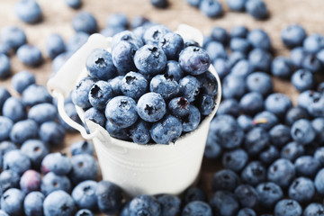 Delicious blueberry or great bilberry in white bucket. Natural and organic superfood.