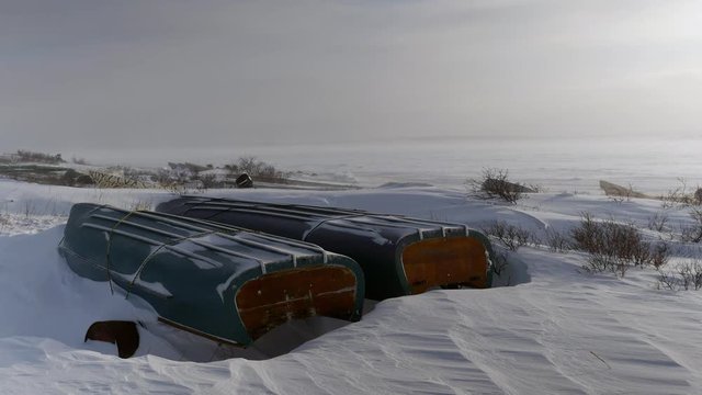 Grounded freighter canoes closeup in winter, wind and snow, northern Quebec on James Bay