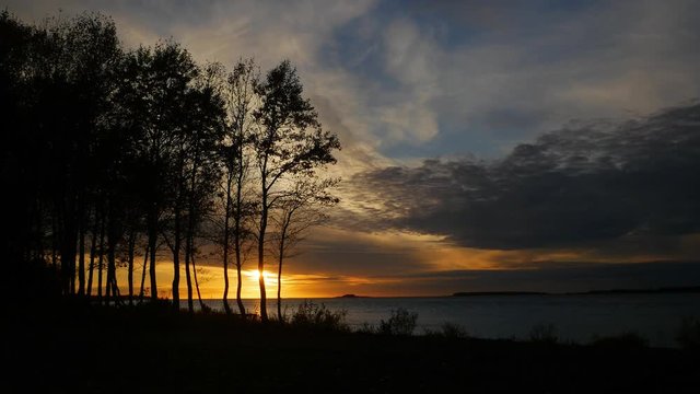 Sunset behind a stand of trees on the Le Grand river, Chisasibi Quebec, near James Bay