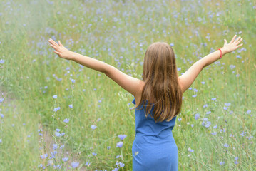 girl in a blue dress on the field of blue flowers