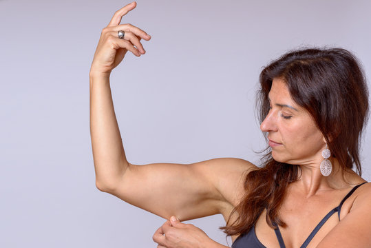 Fit woman pinching the skin of her upper arm