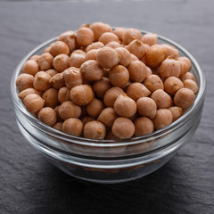 uncooked chickpeas on a dark stone background