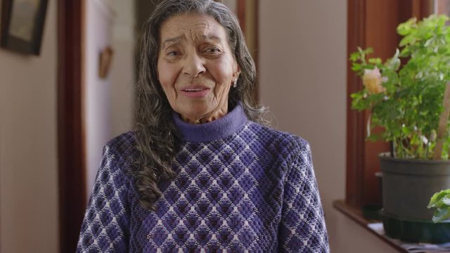 portrait of cheerful elderly indian woman standing hallway smiling laughing enjoying relaxed retirement home