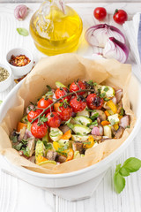 Baked vegetables with mushrooms in white. Zucchini, cherry tomatoes on branch, red onions, bell peppers and garlic. Delicious garnish, vegetarian food, healthy diet