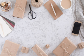 Top view of office stationery and accessories, mobile phone, gift boxes, envelope and cup of latte coffee . Minimalistic flat lay, vintage styled home office desk workspace