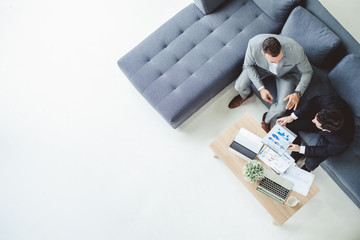 Two business man discussing work on table in office, top view