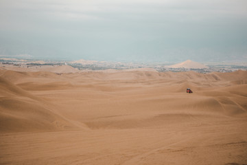 Dune buggy drives across the sand in the Ica desert outside Huacachina, Peru