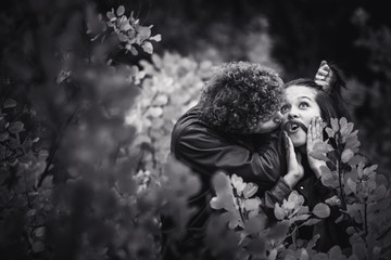 cheerful couple is naughty and shows emotions between autumn trees