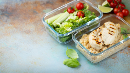 Healthy meal prep containers with quinoa, chicken breast and green salad overhead shot with copy space