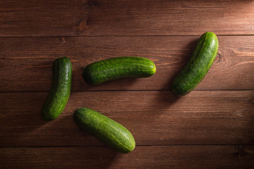 Cucumbers on wooden background, top view