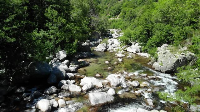 survol d'une cascade et d'une rivi&egrave;re en for&ecirc;t