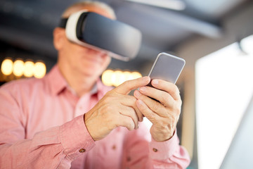 Senior businessman in vr headset using his smartphone while watching webcast