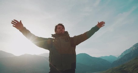 Young hiker reaching the top of mountain and raising his hands. Adventurer achieving a goal. Adventure, zen concept 4k