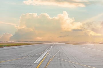 Sunset and cumulus clouds on the road runway in the airport.