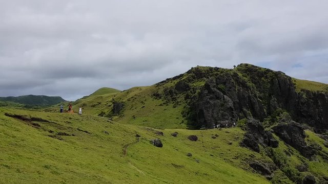 Tourists walking on a mountain sightseeing. Shot in Batanes, Philippines.