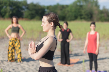 yoga teacher and students practicing yoga outdoors