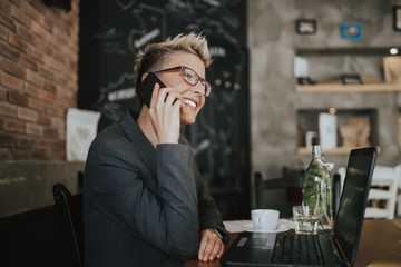 Young positive woman with glasses working in modern office.