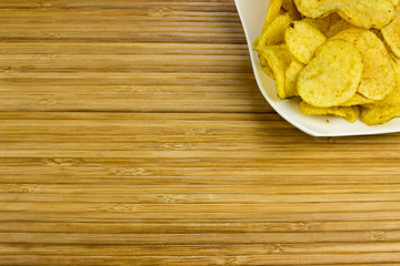 potato chips  on a plate. Wooden table. Salty food for beer