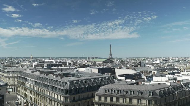 A 4K wide-shot taken from the roof terrace of the Galeries Lafayette in Paris (France) looking at the Eiffel Tower and the rooftops of the city.