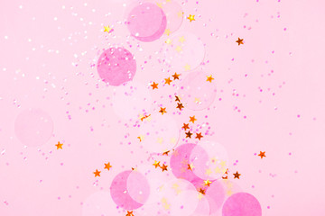 Pink confetti and stars and sparkles on pink background.