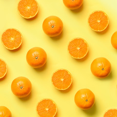 Fruit pattern of fresh orange slices on yellow background. Top view. Copy Space. Pop art design, creative summer concept. Half of citrus in minimal flat lay style. Square crop