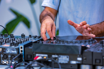 Photo of adult dj working with his equipment. Close up shoot