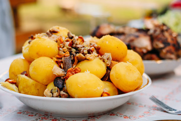Rural boiled potatoes with mushrooms close up in bowl on table