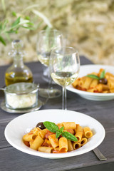  Italian pasta with tomatoes and basil and white wine in rustic interior