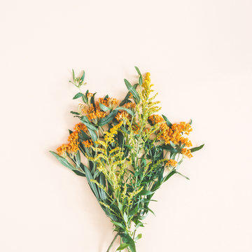 Fototapeta Bouquet made of fresh flowers on pastel beige background. Autumn, fall concept. Flat lay, top view, square