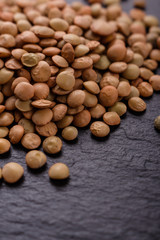 raw lentils on a dark stone background