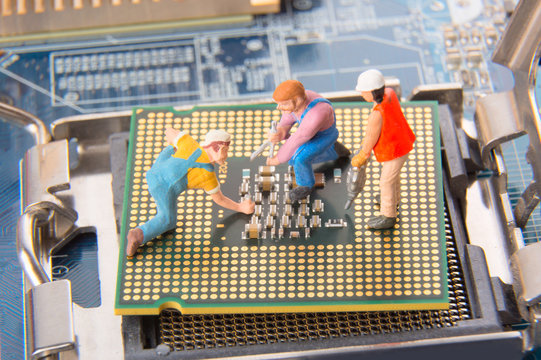 Miniature engineers or technician workers repairing CPU on the motherboard. Computer service and technology concept.