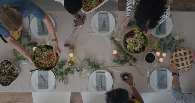 top view young multi ethnic friends preparing table enjoying vibrant thanksgiving dinner together talking bonding over healthy meal