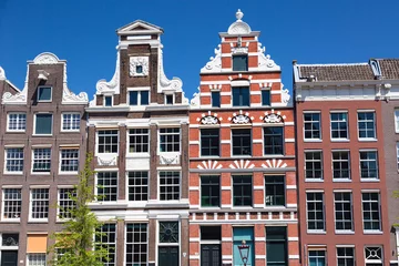 Fotobehang Typical old houses in Amsterdam, Netherlands with blue sky. © Nikolay N. Antonov