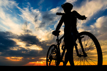 Silhouette of a bicyclist on the sunset background