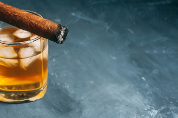 Whiskey on the rocks and a cigar. Top view with copy space.