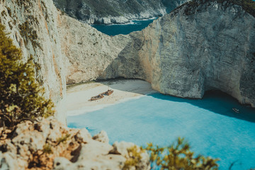 Famous shipwreck on Navagio beach with turquoise blue sea water surrounded by huge white cliffs....