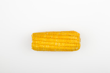 Close-up on oiled corn on the cob isolated on white background, text space