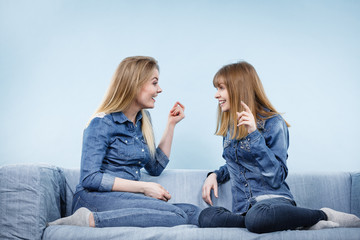 Two happy women friends wearing jeans outfit talking
