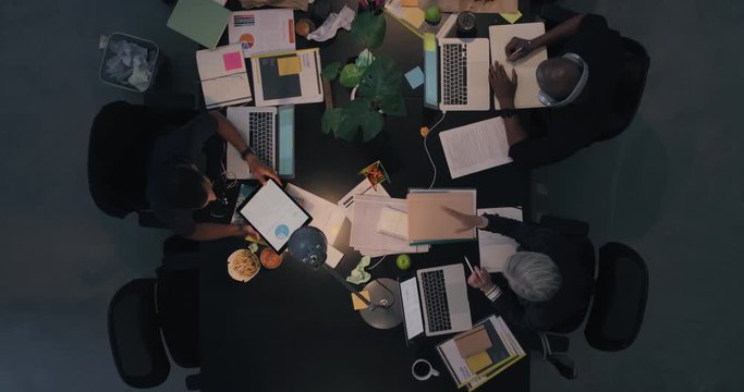 top view diverse business people working late planning strategy for corporate project developing creative ideas in messy boardroom