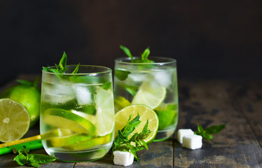 Cold alcohol mahito with mint and lime on a dark background. Summer drink.
