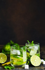 Cold alcohol mahito with mint and lime on a dark background. Summer drink.
