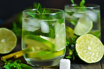 Cold alcohol mahito with mint and lime on a dark background. Summer drink.