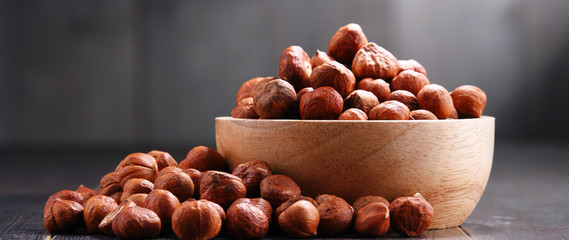 Bowl with hazelnuts on wooden table.
