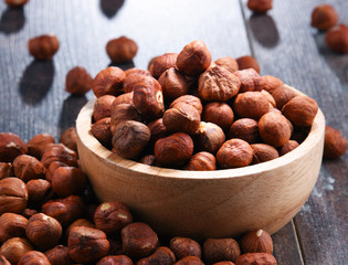 Bowl with hazelnuts on wooden table.