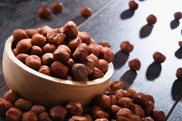 Bowl with hazelnuts on wooden table.