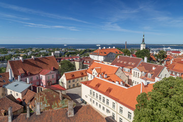 Fototapeta na wymiar Old buildings and St. Olaf's (or Olav's) church's tower at the Old Town in Tallinn, Estonia, viewed from above on a sunny day in the summer.