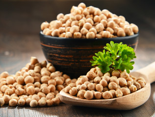 Composition with bowl of chickpeas on wooden table
