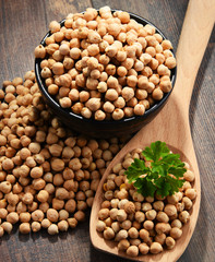 Composition with bowl of chickpeas on wooden table