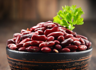 Composition with bowl of kidney bean on wooden table