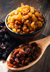 Composition with bowl of raisins on wooden table